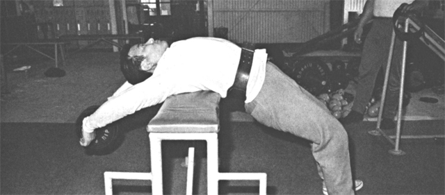 ダンベル・プルオーバー・オン・クロスベンチ（やや高いベンチを利用して、腰の筋肉をほぐし、呼吸を整える）