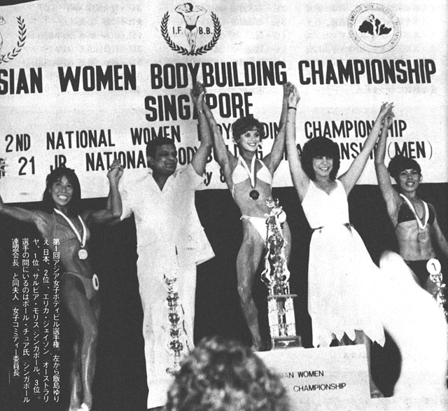 第1回アジア女子ボディビル選手権。左から飯島ゆりえ（日本、2位）、エリカ・ジェイソン（オーストラリヤ、1位）、サルビア・モリス（シンガポール、3位）。選手の間にいるのはポール・チュア氏（シンガポール連盟会長）と同夫人（女子コミティー委員長）